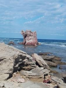 a large rock in the ocean next to the water at "SHARDANA" CASA VACANZe in Gonnesa