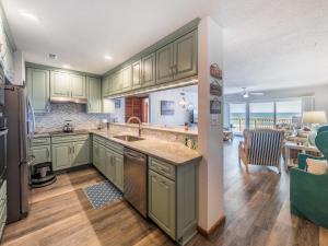 a kitchen with green cabinets and a dining room at Queens Grant 211C in Surf City