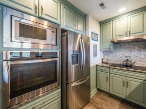 a kitchen with stainless steel appliances and green cabinets at Queens Grant 211C in Surf City