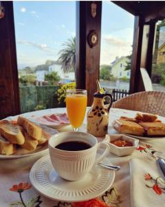 a table with a cup of coffee and bread and orange juice at Posada Las Garzas in Santoña +26 photos