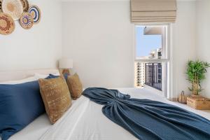 a bed with a blue blanket on it with a window at BohoChic YasIsland: Beside “F1” in Abu Dhabi