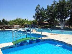 a swimming pool with a slide in the middle at CAMPING-BUNGALOWS-CABAÑAS LA VERA in Jarandilla de la Vera