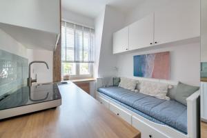 a living room with a couch and a kitchen at DR Apartments - Parkowa in Sopot