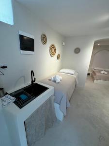 a hotel room with a sink and a bed at White Sand Cave Suite in Ios Chora