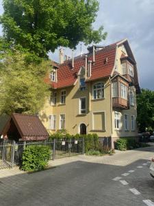 a large yellow house with a red roof at DR Apartments - Parkowa in Sopot