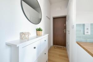 a bathroom with a mirror and a white dresser at DR Apartments - Parkowa in Sopot