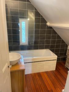 a bathroom with a white tub and a sink at Charmante maison de ville in Caen +7 photos