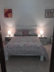Un dormitorio con una cama grande con dos lámparas. en Central apartment in Otrabanda, en Willemstad