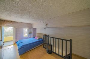 a bedroom with a bed in a room with a balcony at Appart Casamozza Corsica in Lucciana