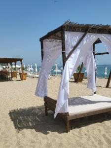 a bed with a canopy on a beach at Квартира студия на берегу моря in Byala