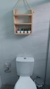 a bathroom with a toilet and a shelf with potted plants at VILLAGE Vista do Cruzeiro ITAITU in Jacobina