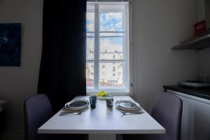 a white table with two plates and a window at Keskusta Business Studio Vanha Postitalo in Varkaus