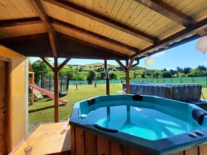a large blue tub in a backyard with a playground at Domeniul Paradisului Relax&Fun in Şmig