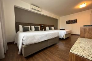 Postel nebo postele na pokoji v ubytování Hotel Deville Curitiba