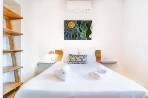 ボルドーにあるMagnifique Appartement Climatise - Proche Garonneのタオルが敷かれた白いベッドのある寝室