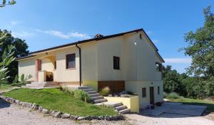 a large white house with stairs in front of it at Studio Apartman Nika in Višnjan