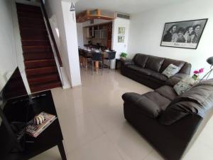 una sala de estar con un sofá y una mesa en JB Beach apartment, en El Morro de Barcelona