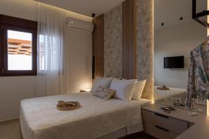 a bedroom with a bed with a hat on it at Evelyn Villa Crete in Tsoutsouros
