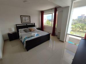 Un dormitorio con una cama y una ventana grande en JB Beach apartment, en El Morro de Barcelona 40 fotos más