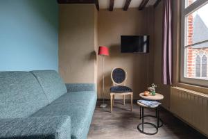 un soggiorno con divano, tavolo e lampada di B&B CONVENT Begijnhof Herentals a Herentals