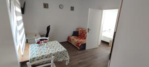 a small living room with a table and a chair at Apartman BS in Velika Gorica +4 photos