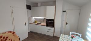 a kitchen with white cabinets and a stove top oven at Apartman BS in Velika Gorica