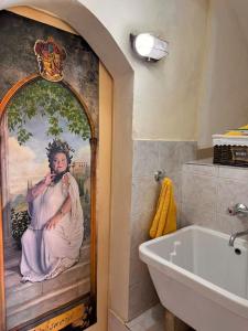Baño con una pintura de una mujer en la pared en Vicolo 9 e tre quarti, en Gaeta 38 fotos más