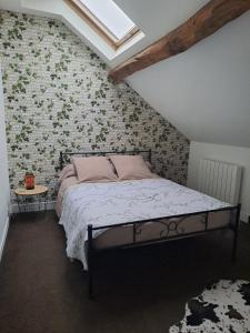 a bedroom with a bed and a wall with flowers at Gîte l'escapade in Crozant