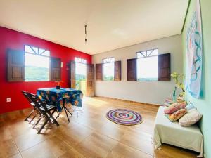 a living room with red walls and a table and chairs at Casa Bela Vista in Lençóis +14 photos