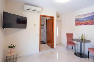 a living room with a table and a tv on the wall at Apartments Linda in Prizba