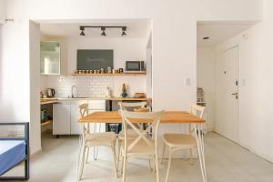 a kitchen and dining room with a wooden table and chairs at Confort en zona Güemes y Shopping Aldrey, a 2 cuadras de la playa. in Mar del Plata