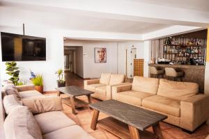 Una sala de estar con sofás y mesas y un bar. en Paul Marie Hotel Apartments, en Ayia Napa