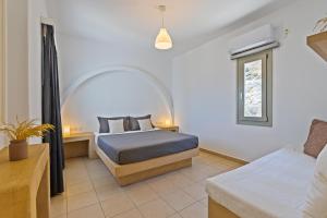 a bedroom with a bed and a window at Lagadia Village in Antiparos