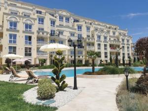 a large apartment building with a pool in front of it at Amber drop with a pool in Ravda