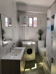 une salle de bain avec une machine à laver et un lavabo dans l'établissement Apartamento en el paseo marítimo de Vilanova de Arousa a pie de playa, à Villanueva de Arosa