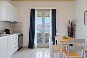 a kitchen with a table and a view of the ocean at Lagadia Village in Antiparos