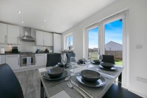 a kitchen with a table with plates and wine glasses at Clapham Wynd House - Grampian Lettings Ltd in Arbroath