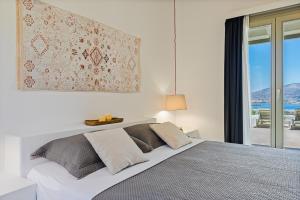 a bedroom with a large bed with a window at Lagadia Village in Antiparos