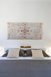 a white bedroom with a bed with two pillows at Lagadia Village in Antiparos