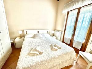 une chambre avec un lit blanc avec deux serviettes dessus dans l'établissement Cottage Rustico 200mt by the Sea, à Forte dei Marmi