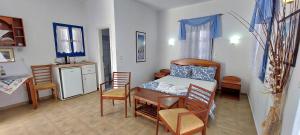 a room with a bed and a table and chairs at Aegean Star Hotel in Karavostasi