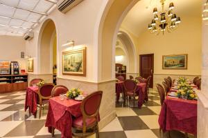 a restaurant with tables and chairs and a chandelier at Hotel Contilia in Rome