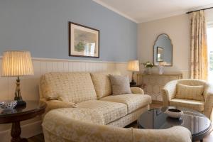 una sala de estar con un sofá y dos sillas en Kouneni Apartments, en Mykonos ciudad