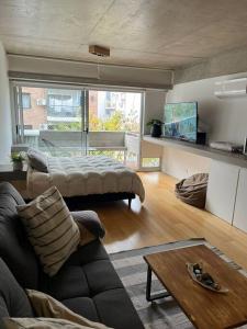 una sala de estar con una cama y un sofá en Apart Soler con balcon, en Buenos Aires