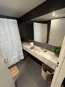 un baño con lavabo y espejo en Apart Soler con balcon, en Buenos Aires 9 fotos más