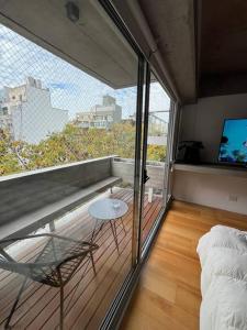 Habitación con balcón, cama y mesa. en Apart Soler con balcon, en Buenos Aires