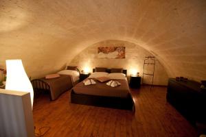 マテーラにあるIl Mulino A Ventoのトンネル付きの部屋にベッド2台付きのベッドルーム1室があります。