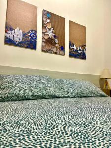 a bedroom with four paintings on the wall at Ciauru di Casa in Porto Palo
