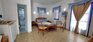 a kitchen and dining room with a table and chairs at Aegean Star Hotel in Karavostasi