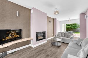 a living room with a couch and a fireplace at Brook Meadow House, 4 bed house, Manchester in Astley